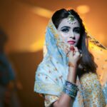 Beautiful Indian bride in traditional attire with intricate jewelry and makeup.