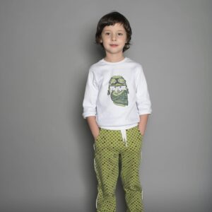 Young boy standing confidently in casual outfit against grey background.